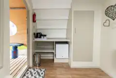 Glamping cabin interior with kitchenette, fridge and kettle