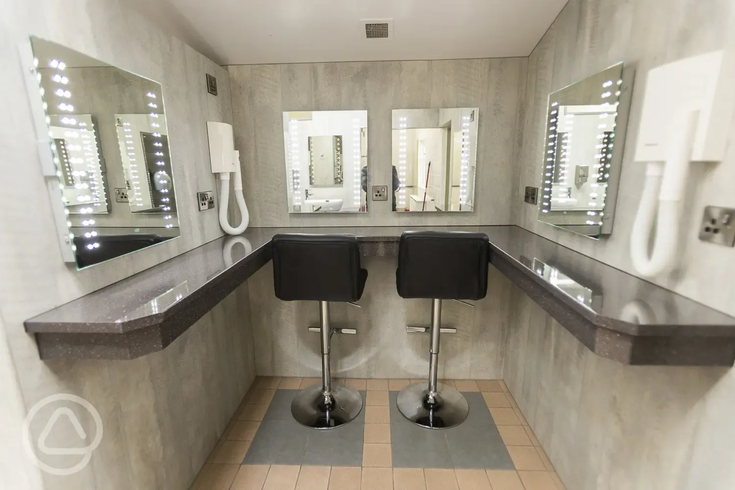 Vanity area with seating, mirrors and hairdryers