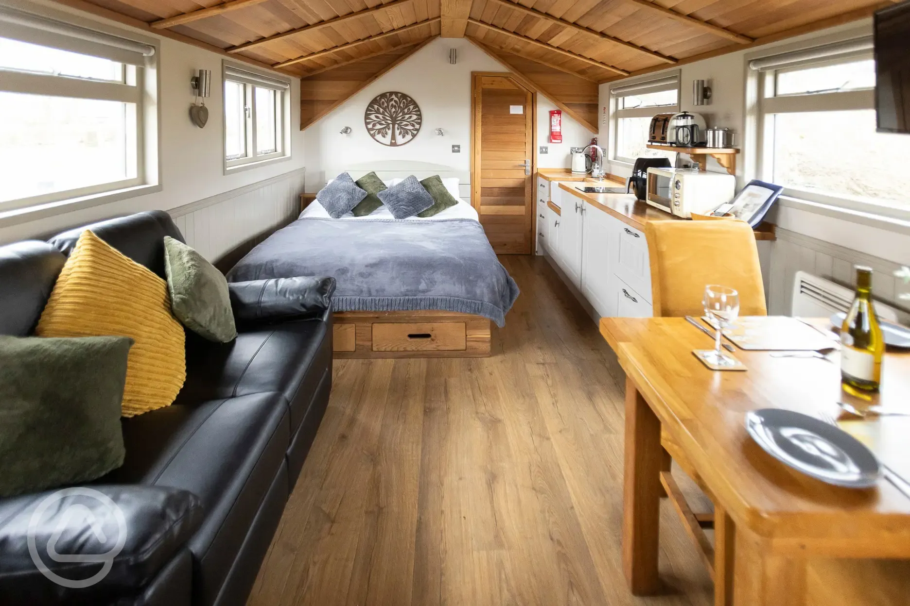 Cedar lodge interior with bedding, kitchen, seating and dining spaces
