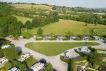 Aerial of the super pitches and glamping cabins with fields in the distance