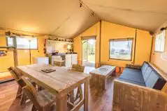 Safari tent with a sofa, dining area and kitchen
