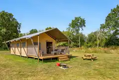 Safari tent with a decking area, picnic table and fire pit