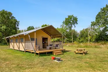Safari tent with a decking area, picnic table and fire pit at Sandyholme 