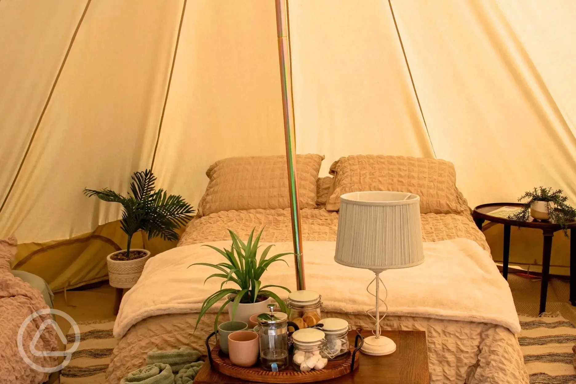 Furnished bell tent with a double bed and twin air beds