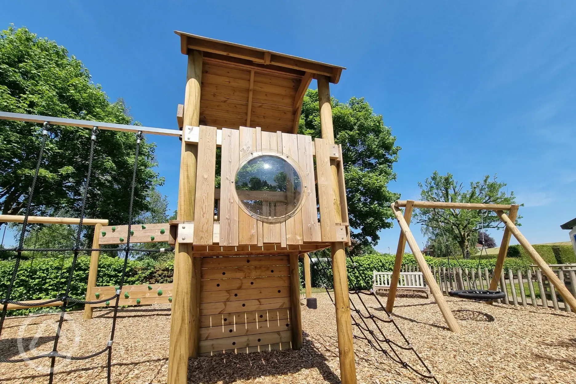 Play park with wooden climbing frames and a swing