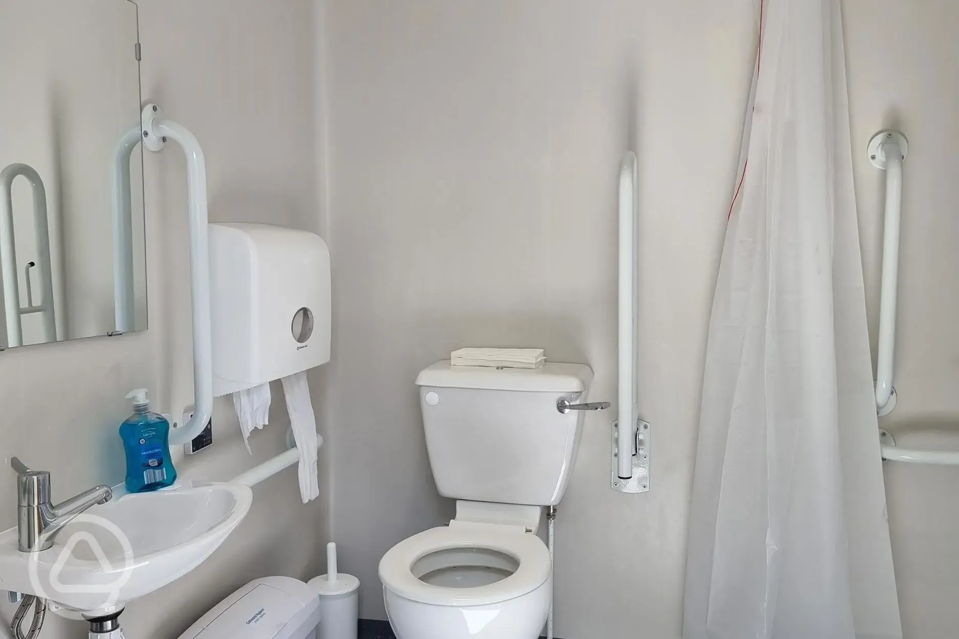 Family/accessible bathroom with grab rails and a shower seat