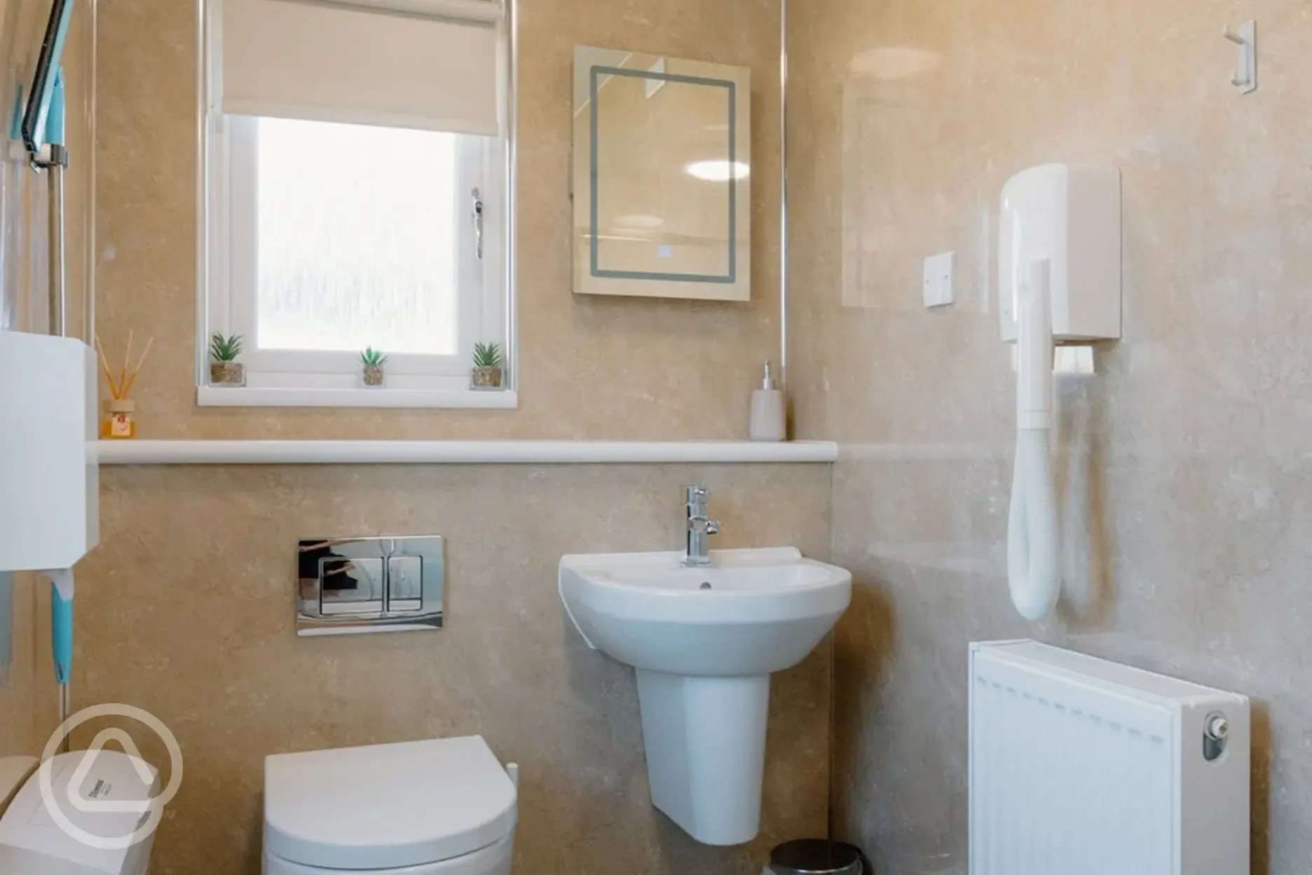 Shared bathroom with a toilet, sink, hand dryer, and mirror Shared bathroom with a toilet, sink, hand dryer, and mirror