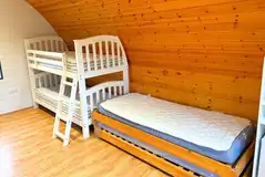 Six person camping pod interior with bunk beds and two singles