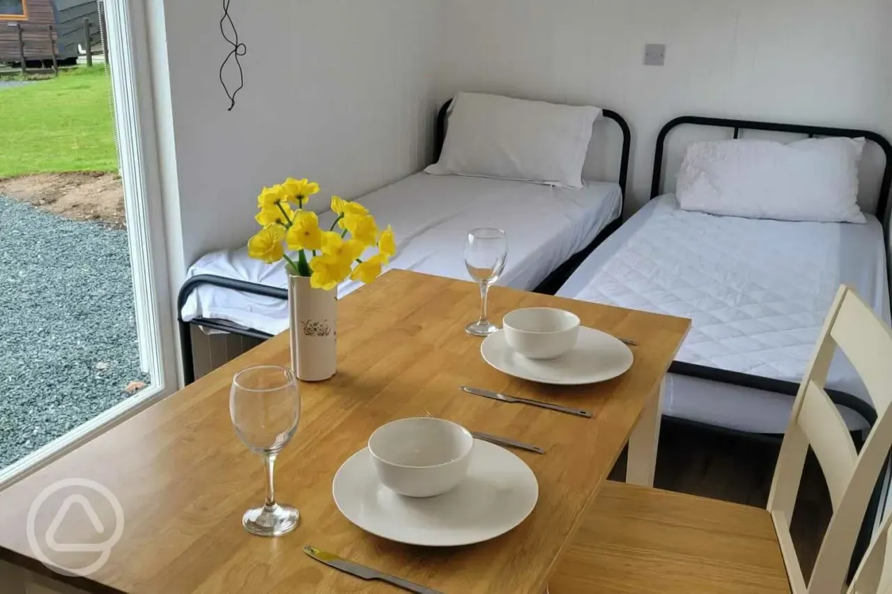 Shepherd's hut with two single beds and a dining table