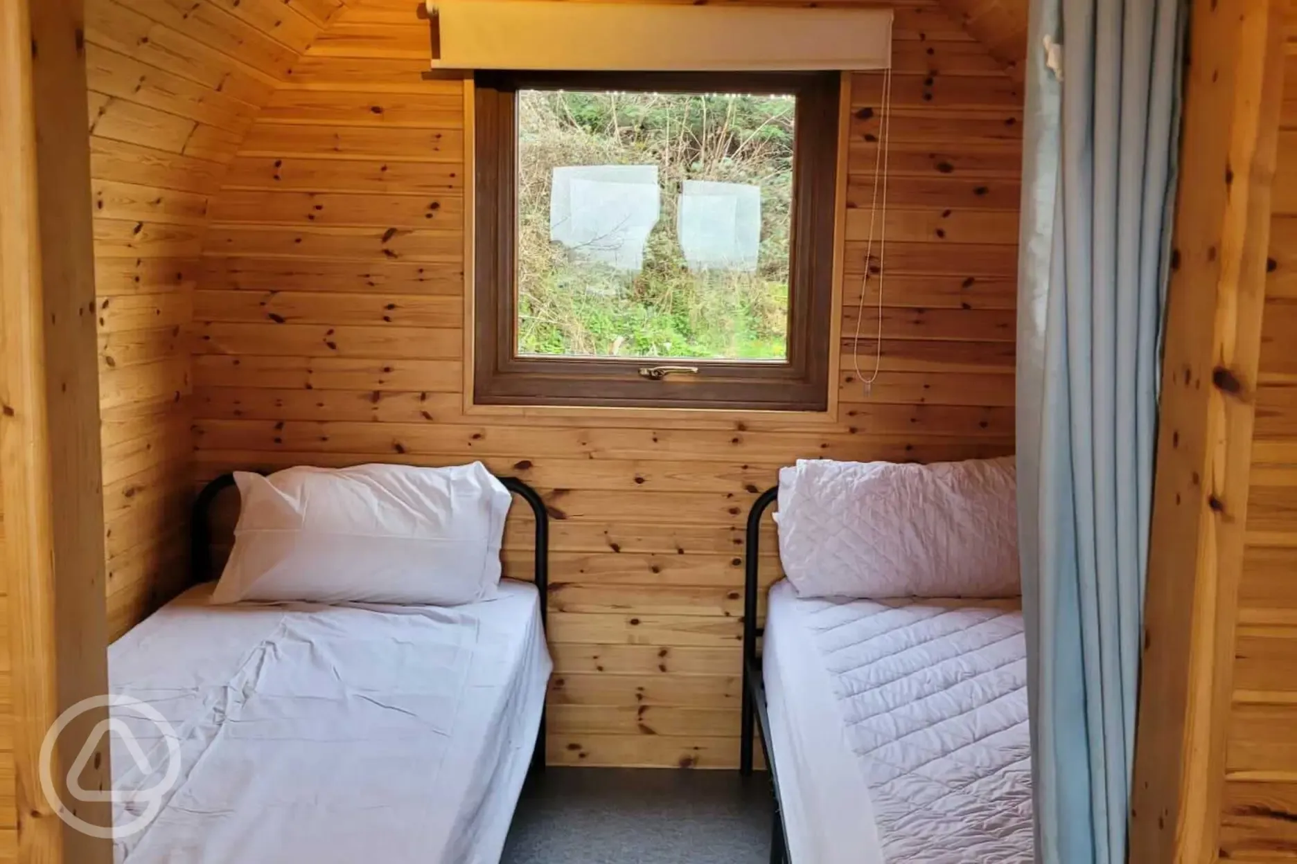 Camping pod interior with twin beds and a double sofa bed (bedding not provided)