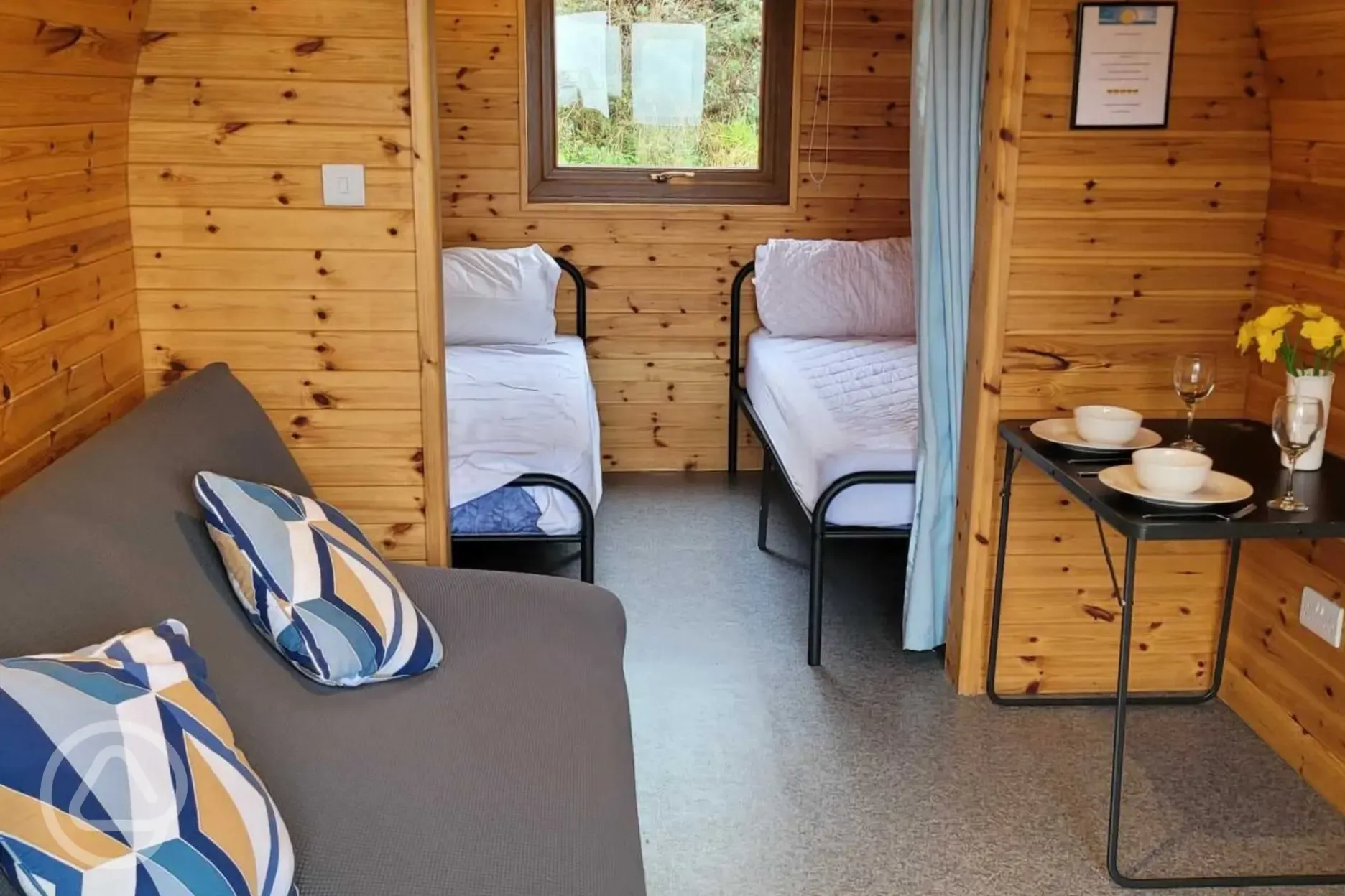 Camping pod interior with twin beds and a double sofa bed (bedding not provided)