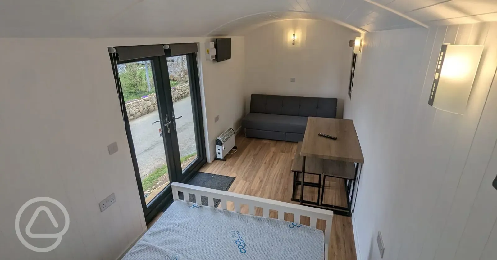 Shepherd's hut featuring a sofa, double bed, and seating