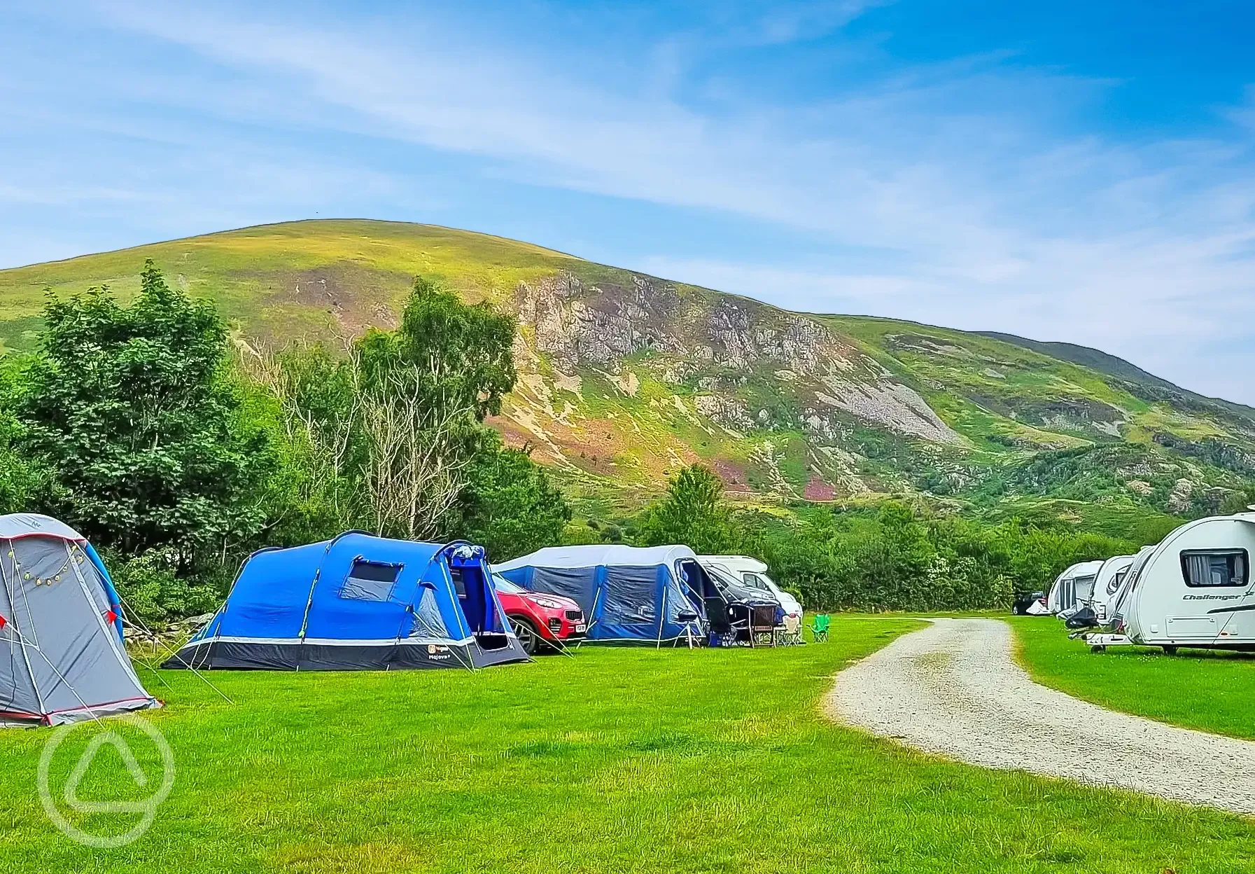 Tents and tourers on the grass pitches that overlook Snowdonia National Park