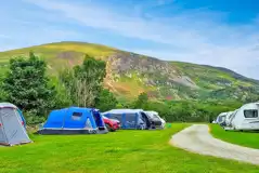 Tents and tourers on the grass pitches that overlook Snowdonia National Park