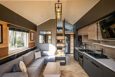 S-pod glamping cabin interior with a sofa area, kitchen and mezzanine level