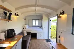 Shepherd's hut with a double bed, bedding and kitchenette