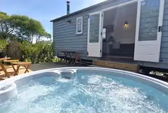 Shepherd's hut with a deck, outdoor seating and hot tub