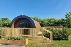 Glamping pod with a raised deck area and hot tub