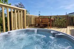 Glamping pod with a raised deck area and hot tub