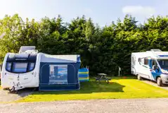 Electric hardstanding pitches with grass areas for awnings