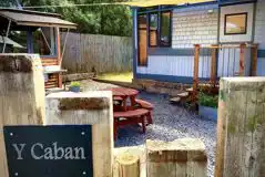 Y Caban garden area with a picnic bench and outdoor kitchen