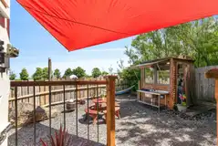 Y Caban garden area with a fire pit, picnic bench and kitchen hut