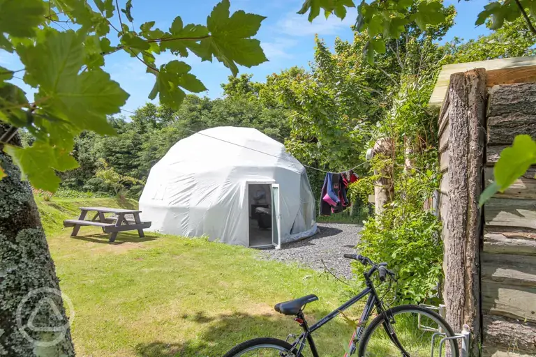 Geodome with a picnic bench, washing line and grass area