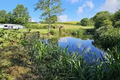 Onsite lake at Pensagillas Park with distant views of the touring pitches