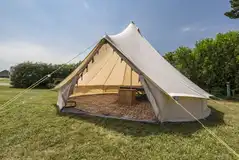 Dingle Bell bell tent exterior with picnic bench Dingle Bell bell tent exterior with picnic bench