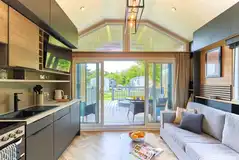 Glamping S-pod interior with a double sofa bed and kitchen