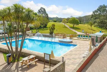 Outdoor swimming pool with a mini splash pad and loungers