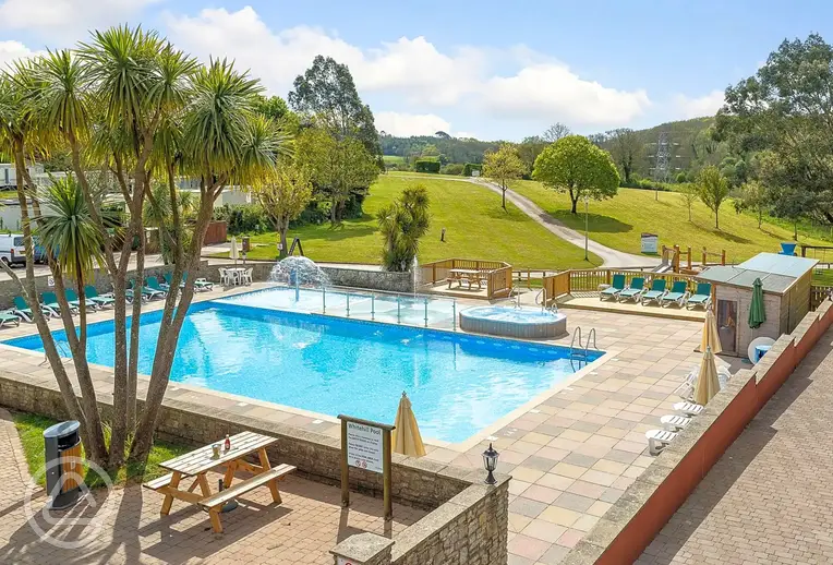Outdoor swimming pool with a mini splash pad and loungers