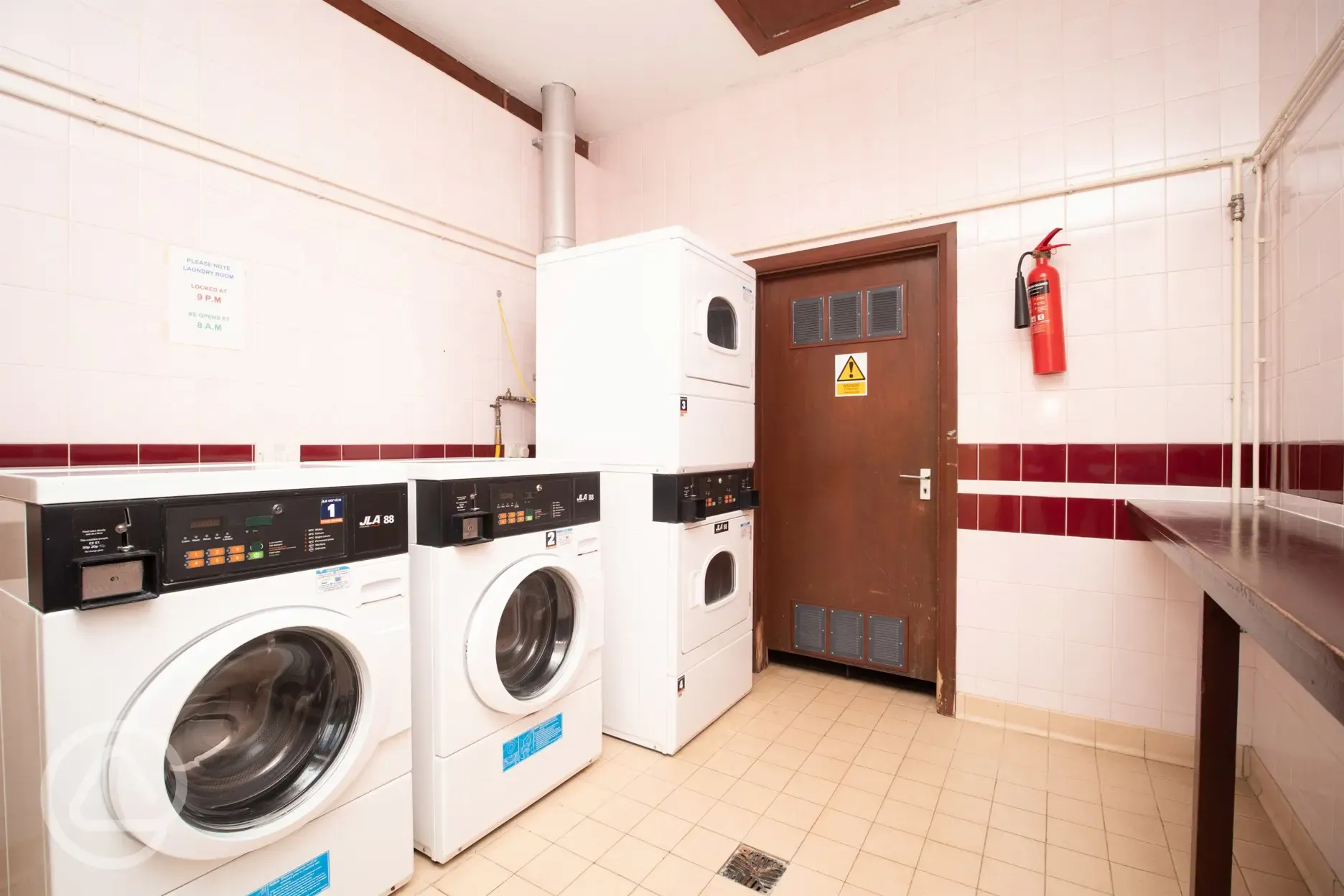 Laundry area at lower wash block with washing machines and tumble dryers
