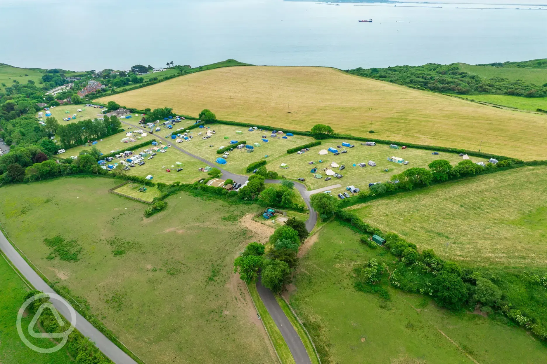 Aerial view of the campsite, surrounded by fields and overlooking Weymouth Bay