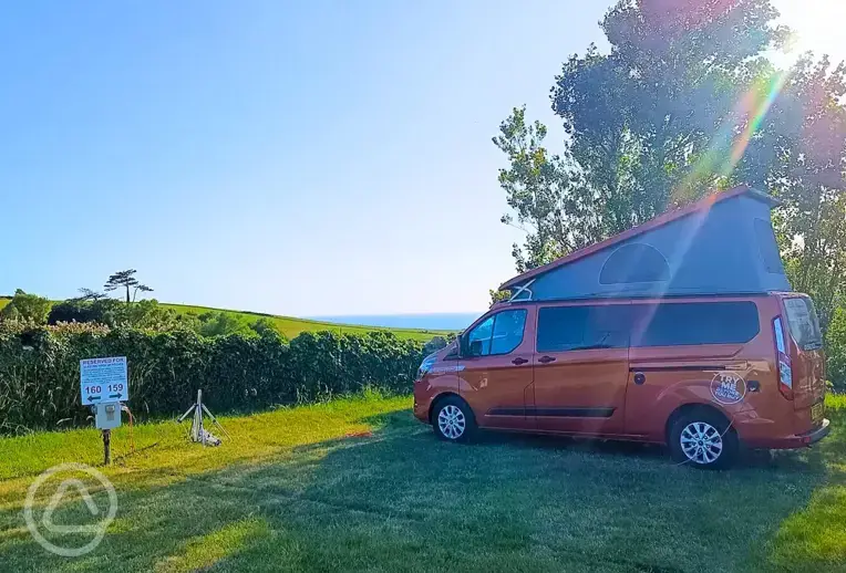 Electric grass campervan pitches with views towards Chesil Beach