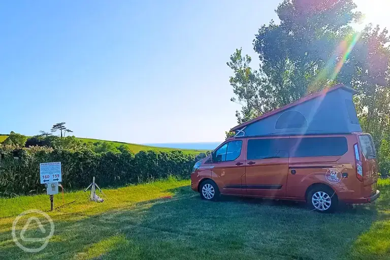 Electric grass campervan pitches with views towards Chesil Beach