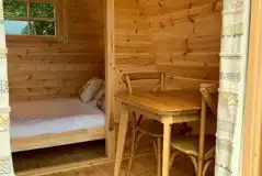 Small camping pod double bed and dining area