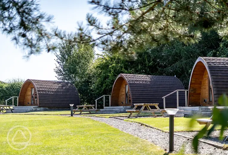 Glamping pods with outdoor deck areas and picnic benches