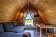 Glamping pod sofa bed, dining area and TV