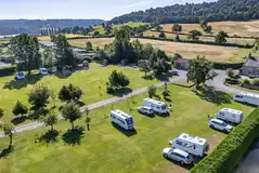 Aerial of the electric grass touring pitches with trees around site Aerial of the electric grass touring pitches with trees around site