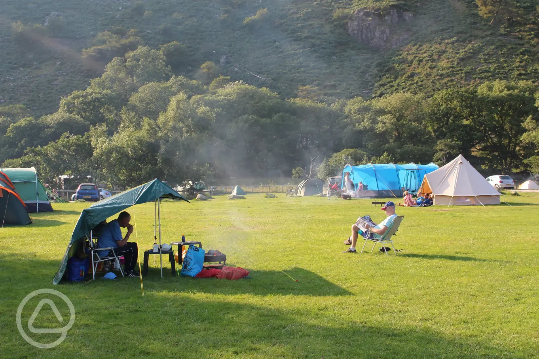 Large grass camping areas surrounded by mountains