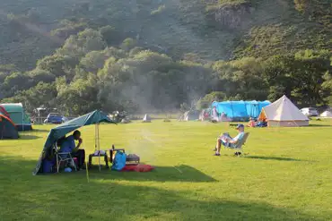 Large grass camping areas surrounded by mountains