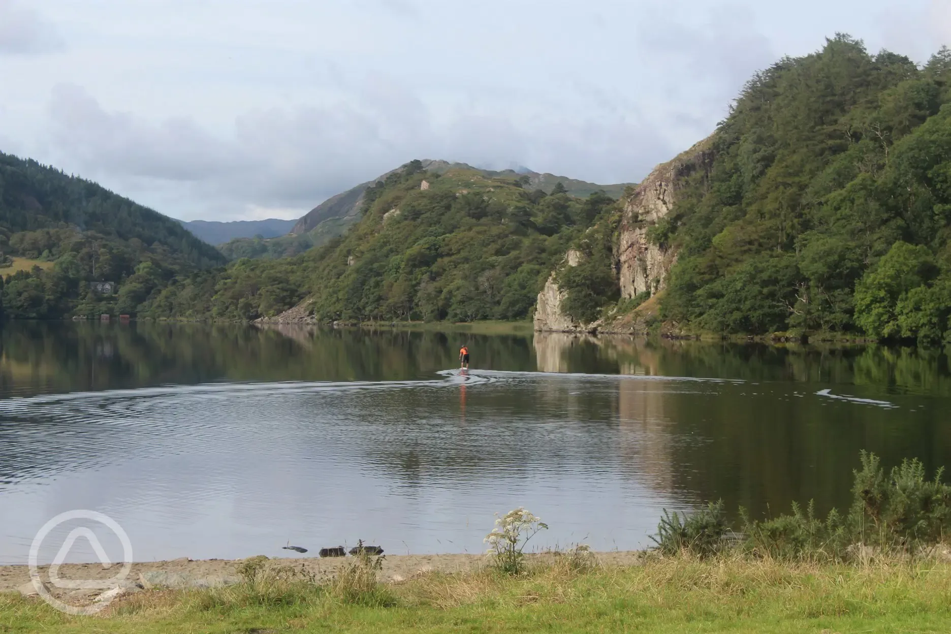 A standup paddle boarder enjoying a tranquil Llyn Gwynant.