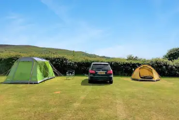 Grass tent pitches with optional electric and space to park alongside