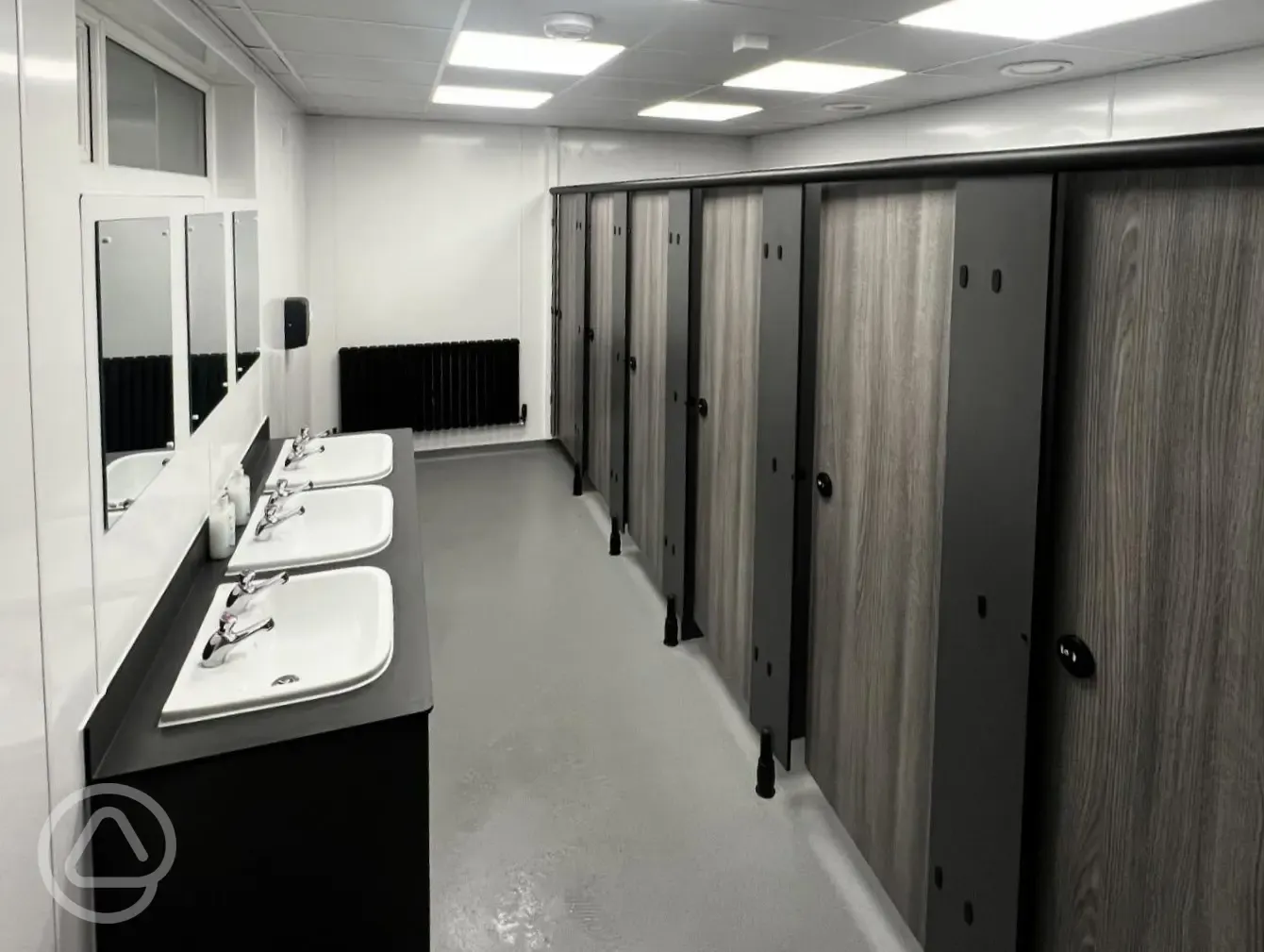 Showers and toilet cublicles with mirror and sinks