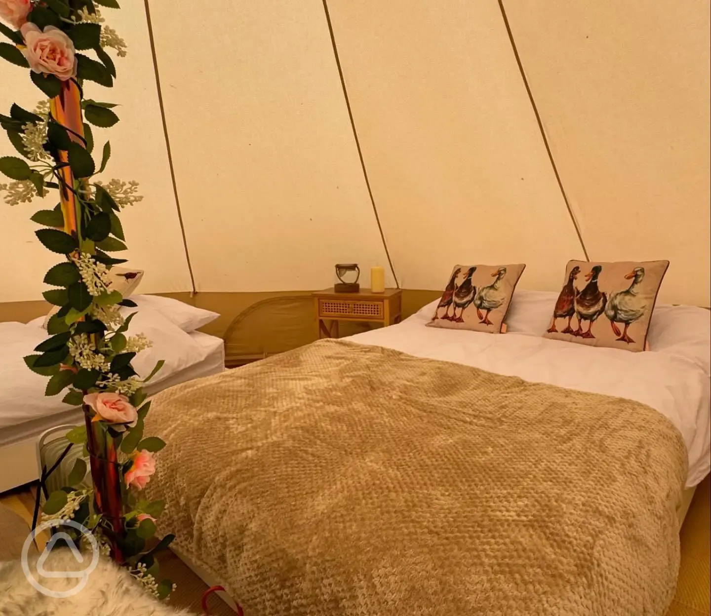 Bell tent interior with double bed, bedding is provided