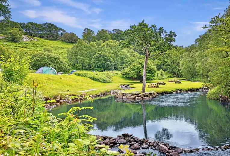 Grass camping pitches at Nantcol Waterfalls by the river