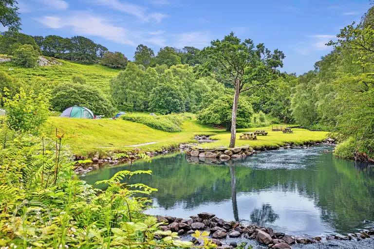 Grass camping pitches at Nantcol Waterfalls by the river