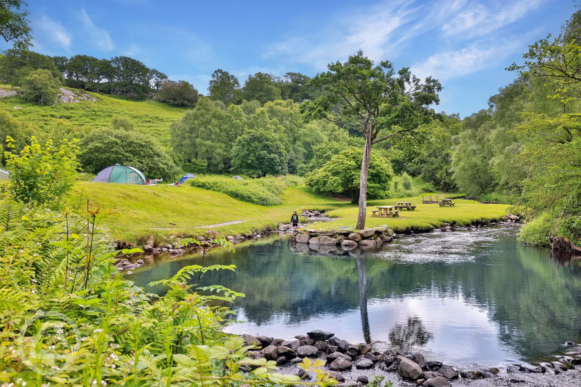 Grass camping pitches by the waterfall