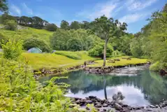 Grass camping pitches by the waterfall